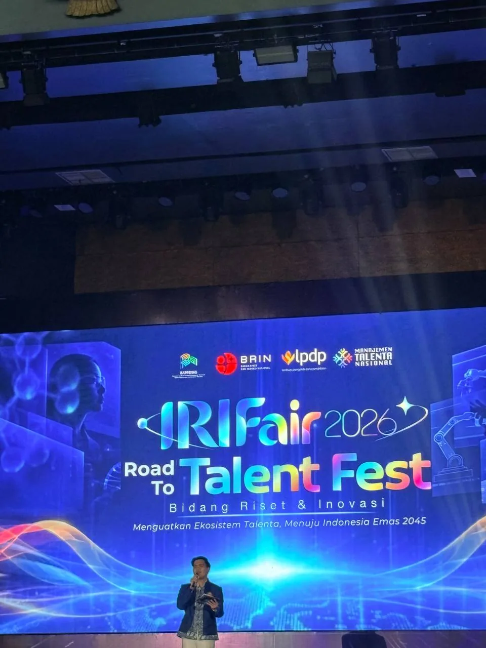 Pembicara memegang mikrofon di panggung utama IRIFair 2026
